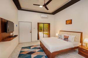 a bedroom with a bed and a flat screen tv at Mango Serene by Roamigo in Karjat +24 photos