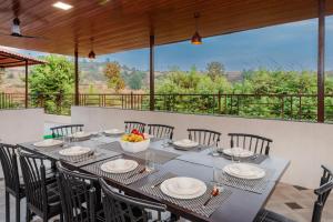 a dining room with a table and chairs at Mango Serene by Roamigo in Karjat
