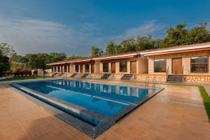 a swimming pool in front of a house at Mango Serene by Roamigo in Karjat