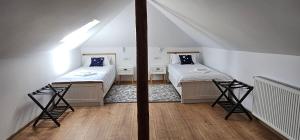 a room with two beds in a attic at Vila Trifoi Apartamente in Breaza de Jos