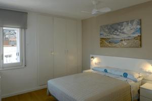 a white bedroom with a bed and a window at Pedro in Roses