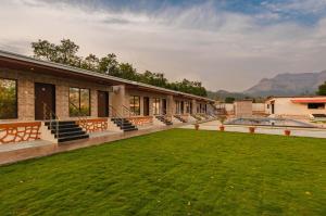 a house with a green lawn in the yard at Mango Serene by Roamigo in Karjat