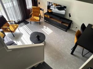a living room with a television and a table and chairs at Prins Heerlijk Amelander Kaap 81 in Hollum