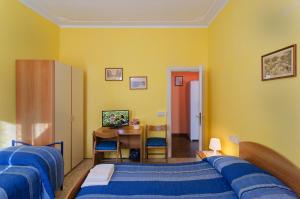 a bedroom with two beds and a desk and a table at Il Ponte Affittacamere in Lucca