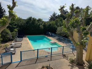 an empty swimming pool with lounge chairs and trees at Philippe in Beaurecueil