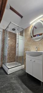 a bathroom with a glass shower and a sink at Vila Trifoi Apartamente in Breaza de Jos +42 photos