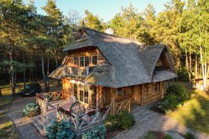 a large log cabin with a thatched roof at Leśna Oaza in Sierpc