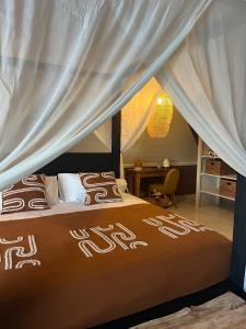 a bedroom with a bed with a canopy at La Belle du Sud in Saint-Joseph