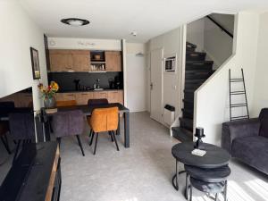 a living room and kitchen with a table and chairs at Prins Heerlijk Amelander Kaap 81 in Hollum