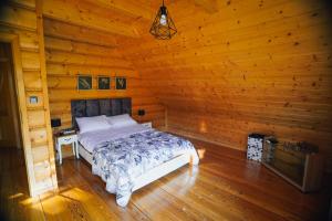 a bedroom with a bed in a log cabin at Leśna Oaza in Sierpc