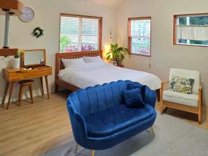 a bedroom with a large bed and a blue chair at Bandi House in Seogwipo