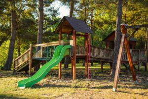a playground with a green slide and a gazebo at Leśna Oaza in Sierpc