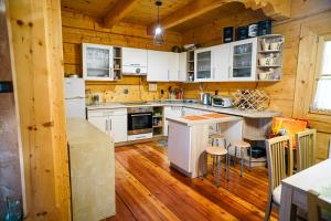 a kitchen with wooden floors and white appliances in a cabin at Leśna Oaza in Sierpc