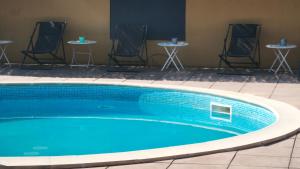 a swimming pool with chairs and tables in a room at STRAVINSKY Apartments Avignon - Get our Last best deals ! in Avignon