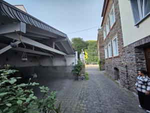 a woman standing in front of a brick building at Gästenzimmer Louis in Ediger-Eller