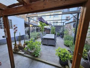 an outdoor patio with a table and some plants at Gästenzimmer Louis in Ediger-Eller