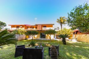 a house with a yard with chairs and trees at Oasi Scolacium in Villaggio Le Rocelle