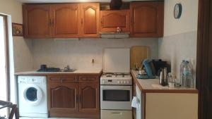 a kitchen with wooden cabinets and a washer and dryer at Maison clara 2 rue du centre in Clara +3 photos