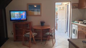 a kitchen with a table and a tv and a table and chairs at Maison clara 2 rue du centre in Clara
