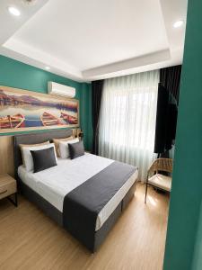 a bedroom with a large bed and a television at Deniz Boutique Hotel in Antalya