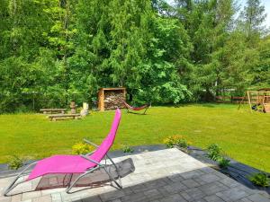 a pink chair sitting in the middle of a yard at Przystanek Bereżnica in Bereżnica Wyżna