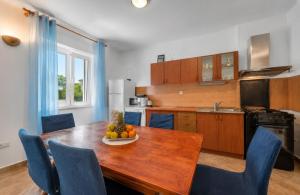 a kitchen with a table with a bowl of fruit on it at Apartman Arija-Pino in Vodice