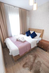a bedroom with a bed with blue pillows and a window at Classic Suite MK1 in Istanbul