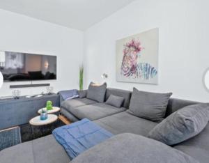 a living room with a gray couch and a table at Apartman Arija-Pino in Vodice
