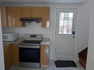 a kitchen with a stove top oven next to a door at Private Room in Guest House, Near the New Oakridge Mall & Transit - Near Langara 49th Station in Vancouver +35 photos