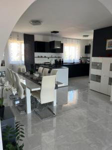 a kitchen and living room with a table and chairs at Apartman Ariana in Ližnjan