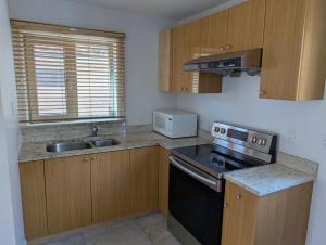 a small kitchen with a stove and a sink at Private Room in Guest House, Near the New Oakridge Mall & Transit - Near Langara 49th Station in Vancouver
