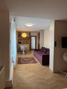 a living room with a purple couch and a table at Lucas 10 Apartments in Cluj-Napoca