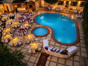 an overhead view of a swimming pool with chairs and umbrellas at Karnak Hotel Luxor in Luxor