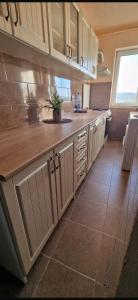 a kitchen with white cabinets and a tile floor at Modern Panoramic View Apartament in Sighetu Marmaţiei