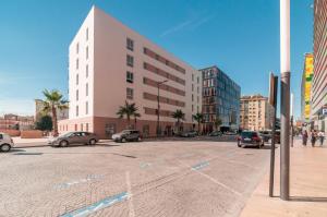 una calle de la ciudad con coches aparcados en un estacionamiento en Appart'City Confort Perpignan Centre Gare en Perpiñán