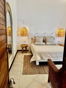 a white bedroom with a bed and a mirror at Little Palm Penthouse in Cap Malheureux