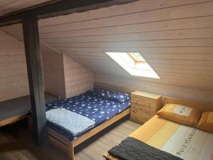 a small attic bedroom with a bed and a window at Noclegi Zakątek in Okuninka