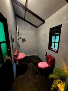 a bathroom with a pink toilet and a sink at Sampath State in Koslanda