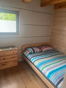 a small bedroom with a bed and a window at Noclegi Zakątek in Okuninka