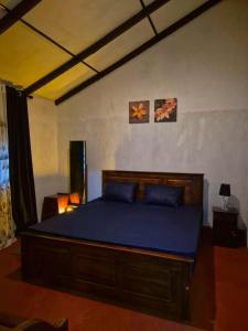 a bedroom with a large bed with blue sheets at Sampath State in Koslanda