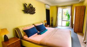 a bedroom with a large bed with blue pillows at Luxury Beachfront SeaView Apartment in Ko Chang