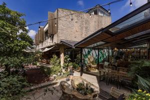 an outdoor patio with tables and chairs and a brick building at TTR Rin Villa & Hotel in Da Lat
