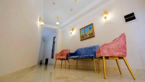 a room with two chairs and a painting on the wall at The Garden of Shaherezade in Bukhara