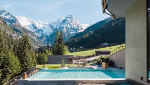 a swimming pool with mountains in the background at Hotel Bella Vista in Trafoi