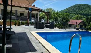 a swimming pool in front of a house at Holiday Residence Šehić in Visoko