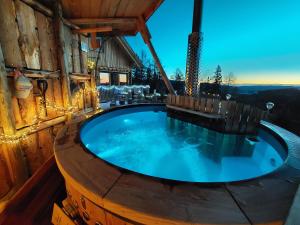 a hot tub in a wooden house with lights at Chalet Die Berghexn in Klippitztorl