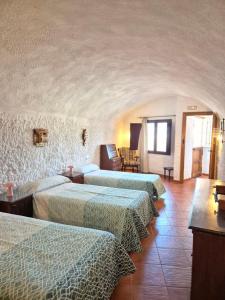 a group of three beds in a room at Cuevas La Cocinillas in Graena +184 photos
