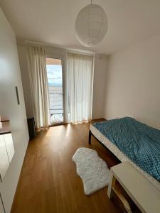 a bedroom with a bed and a large window at Cozy Apartment in Graz