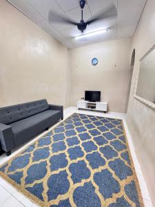 a living room with a couch and a tv at D Anggun Homestay in Kampung Gurun