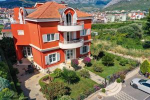 an orange house with a garden in front of a city at Apartmani Villa Biočić in Split